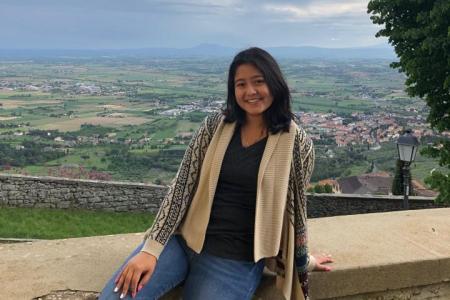 Jamie in front of a scenic Italian landscape.